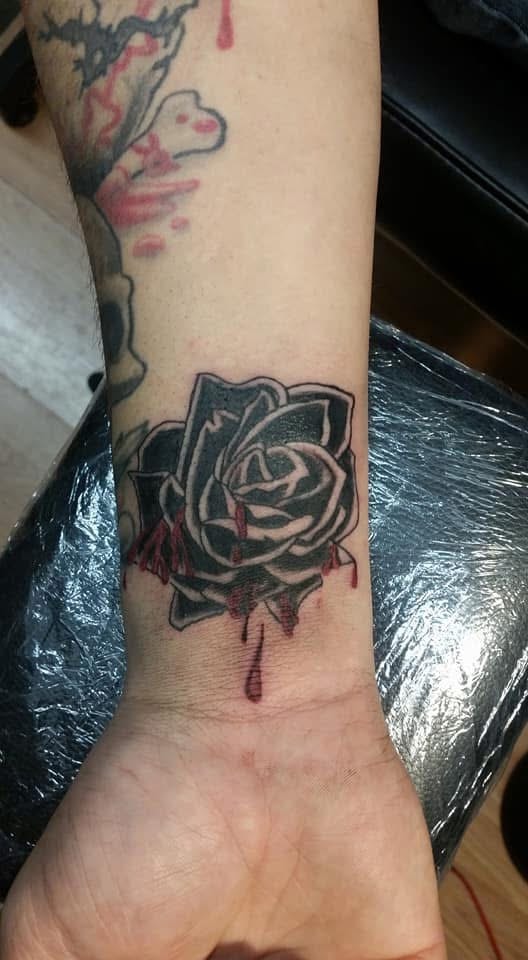 Black rose with red dripping blood wrist tattoo