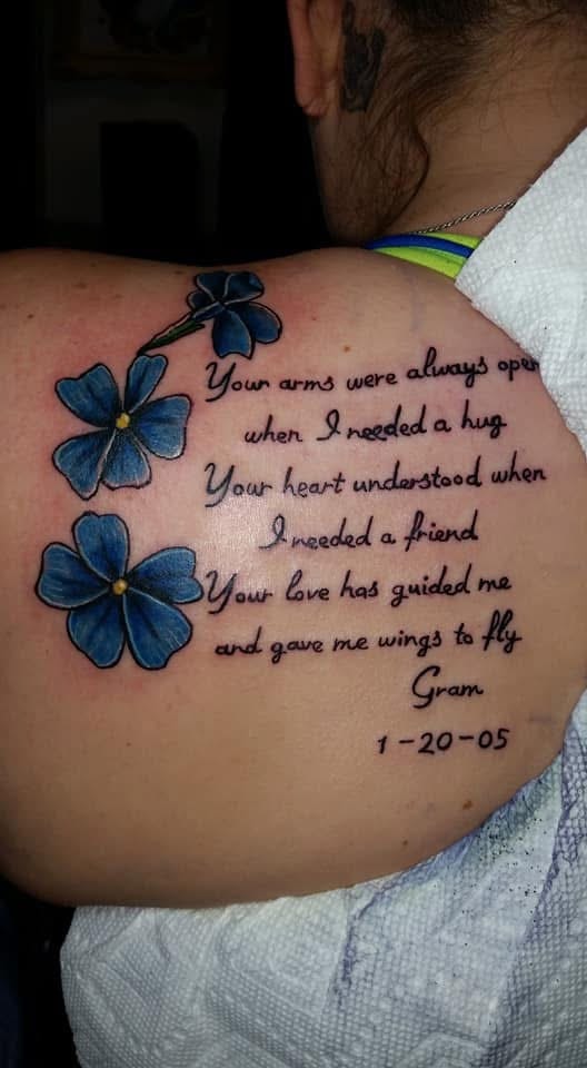 Blue forget-me-not flowers with Gram memorial script back shoulder tattoo