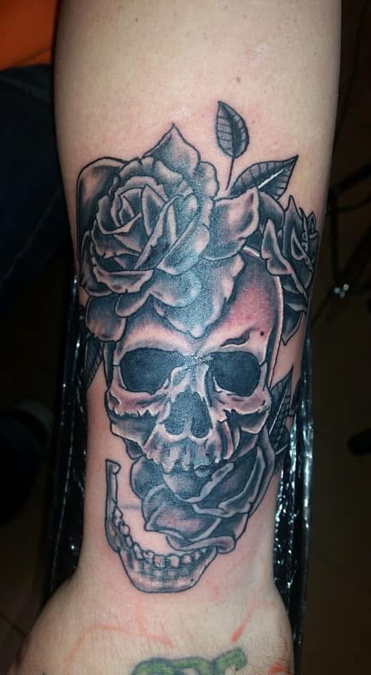 Skull crowned with black and grey roses forearm tattoo
