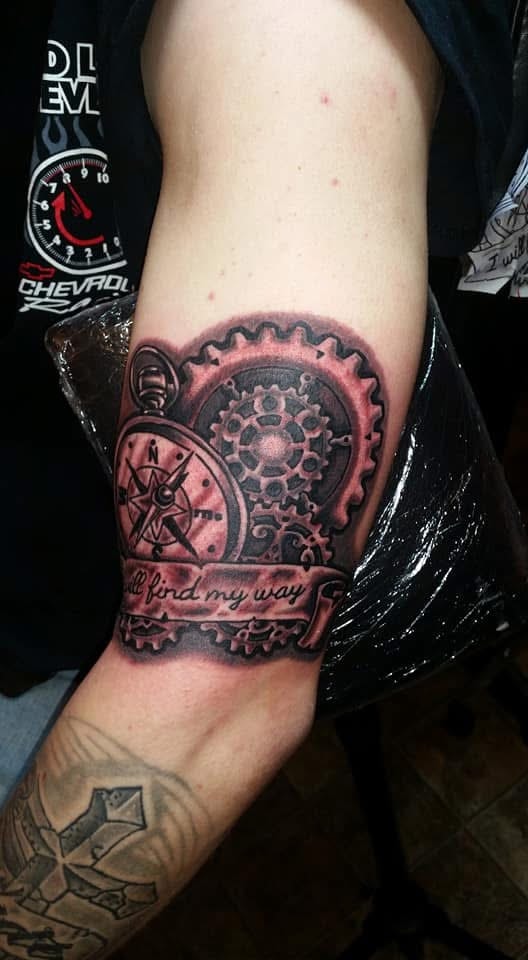 Steampunk compass and gears with I'll find my way banner arm tattoo