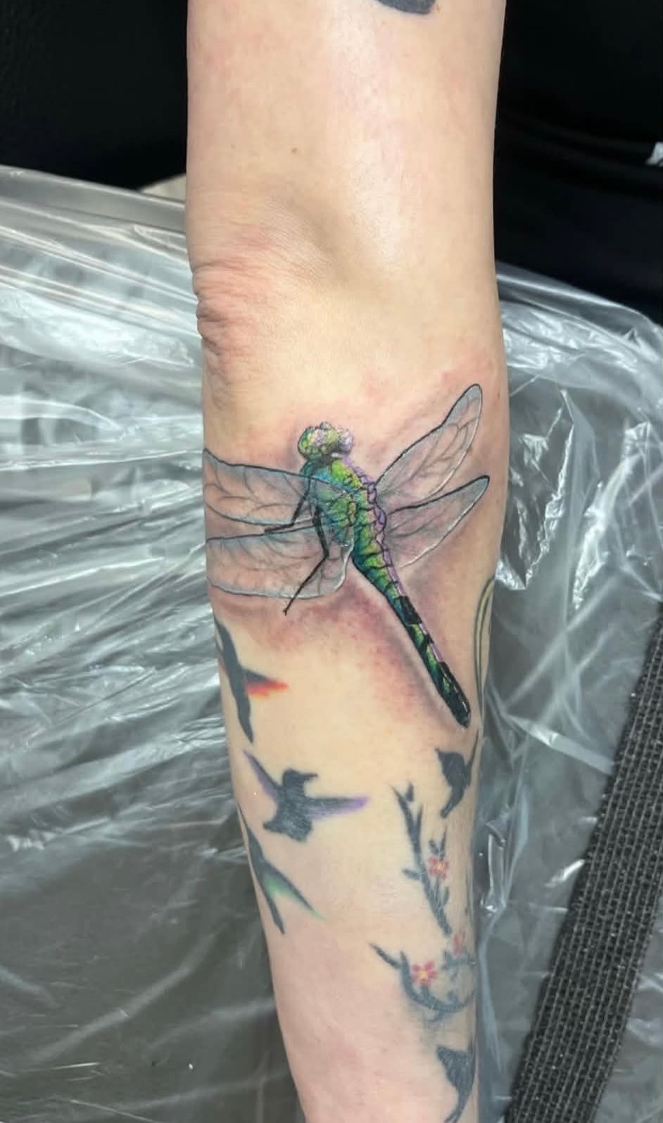 Jayden Levin green dragonfly with birds forearm tattoo