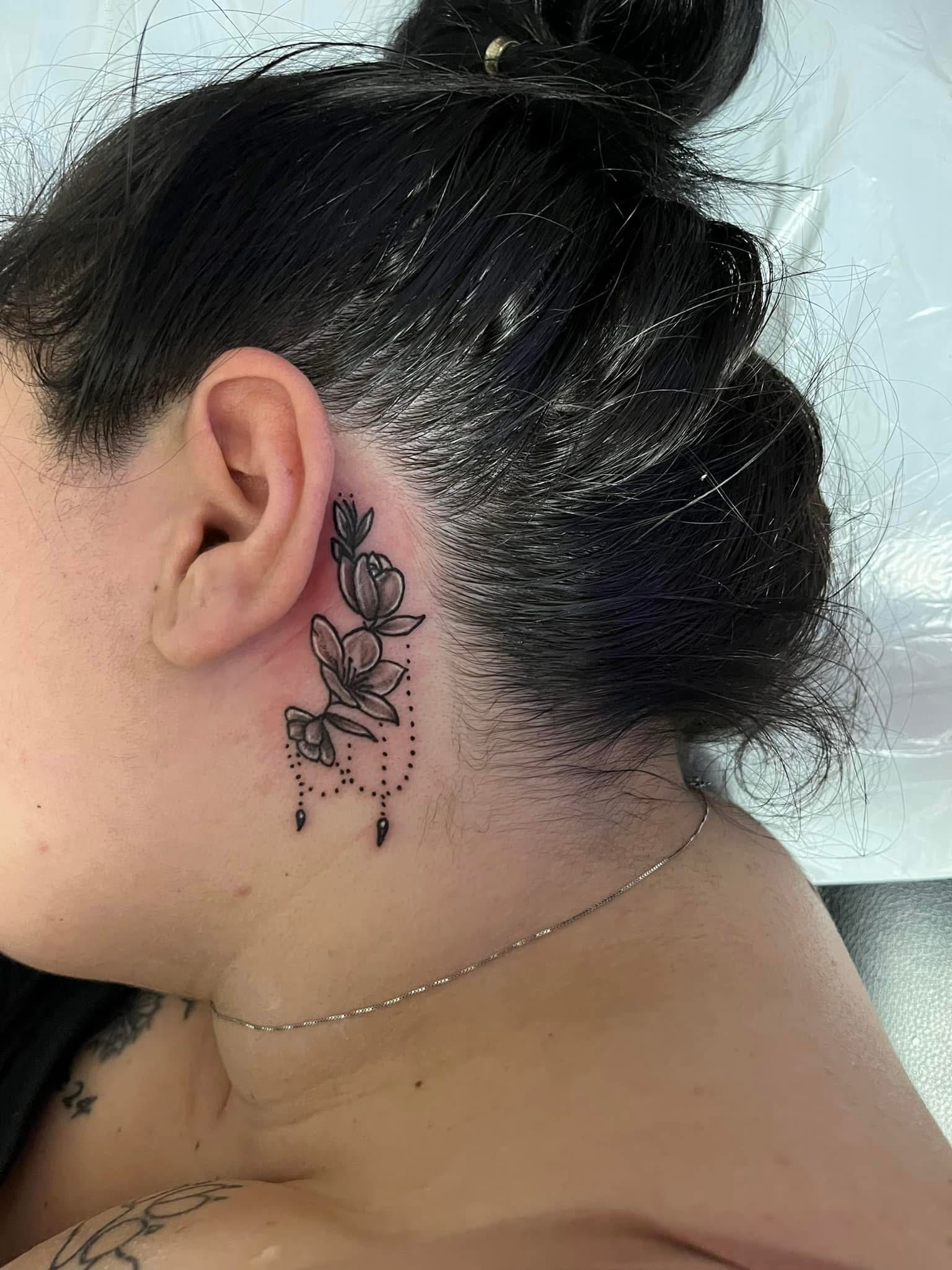 Delicate floral with dot chandelier behind the ear tattoo