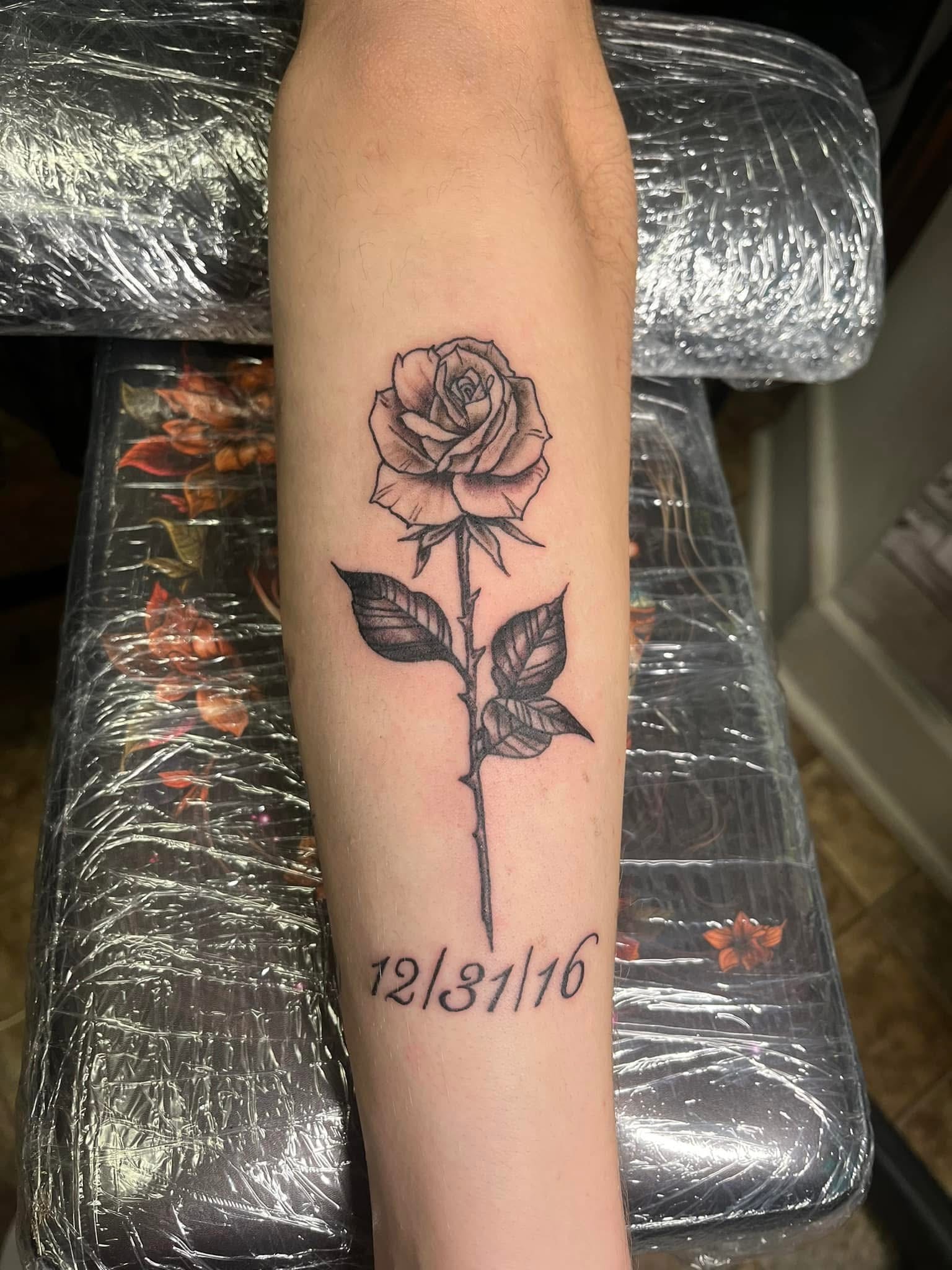 Black and grey rose with memorial date 12/31/16 forearm tattoo
